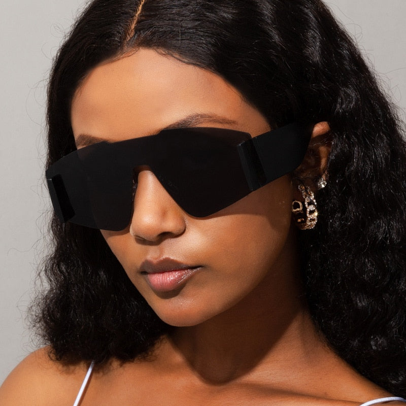 "Lunettes de soleil oversize en une pièce, style catwalk féminin pour un look audacieux et élégant. Protection UV et confort pour les journées ensoleillées."